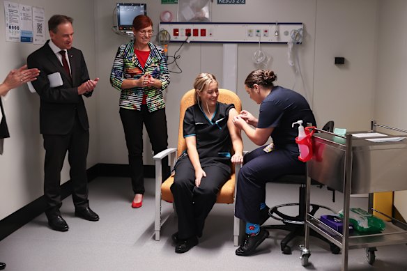 Minister for Health and Aged Care Greg Hunt and ACT Minister for Health Rachel Stephen-Smith observe as COVID testing nurse Maddy Williams receives the first COVID-19 vaccination in the ACT.