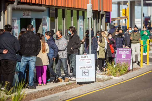 People queue for COVID-19 vaccines in 2021. 