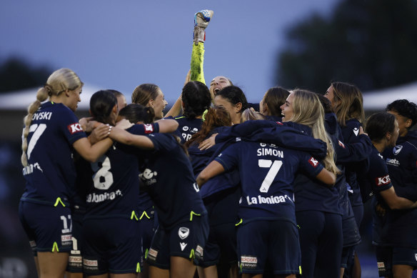 Melbourne Victory goalkeeper Casey Dumont raises her fist to celebrate with teammates.