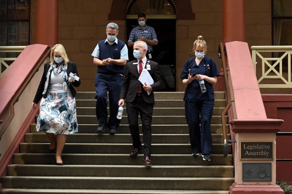 Members of NSW health leave NSW Parliament House which was suspended after NSW Agriculture Minister Adam Marshall tested positive for COVID-19 in June.