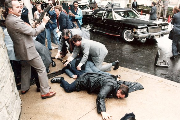 Un agente stampa ferito e un membro dei servizi segreti giacciono proni sulla scena dell'attentato del 1981 al presidente Ronald Reagan.