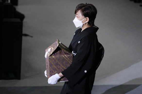 Akie Abe, ölen kocasının küllerini içeren bir vazoyu eyalet cenazesine taşıyor 