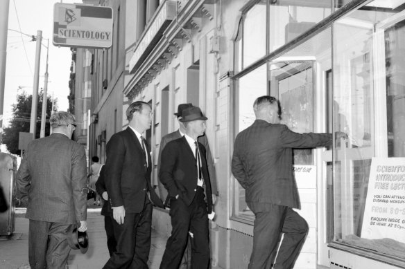 Police enter the Melbourne offices of Scientology on Spring Street.
