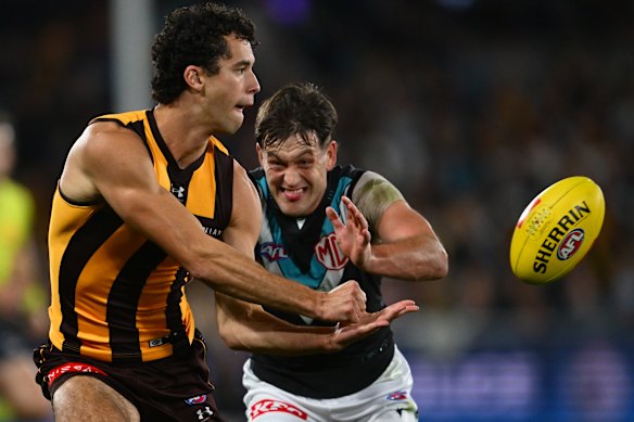 Will McCabe fires away a handball with Zak Butters in hot pursuit.