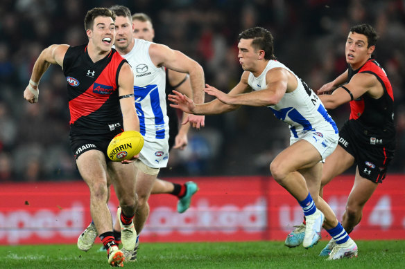 Zach Merrett handballs for the Bombers in their nailbiting win over the Kangaroos.