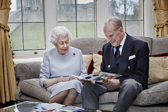 Well wishes: the Queen and Prince Philip read a homemade wedding anniversary card, given to them by their great grandchildren.