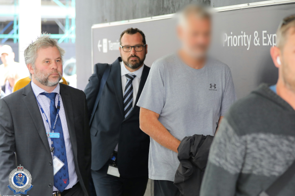 Toll, 55, in handcuffs at Kingsford Smith Airport on Thursday.