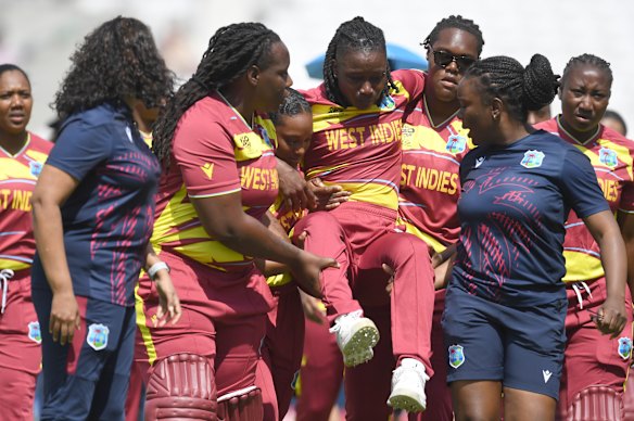 Deandra Dottin is carried from the field by teammates. 