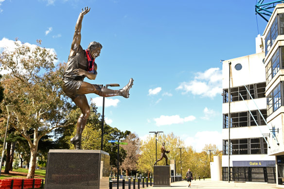 A Demons scarf is draped around the statue of Barassi outside the MCG.