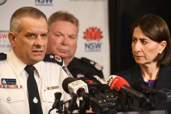 Rob Rogers (left) has won the support of Premier Gladys Berejiklian  (right) and her cabinet to remain in the job as Rural Fire Service commissioner beyond his one-year appointment.