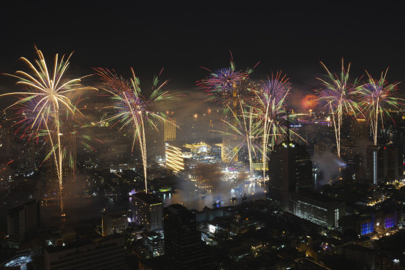Fireworks explode over the Chao Phraya River during New Year celebrations in Bangkok, Thailand.