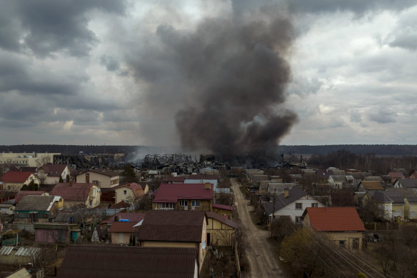 A factory and a store burn after being bombarded in Irpin on Sunday.