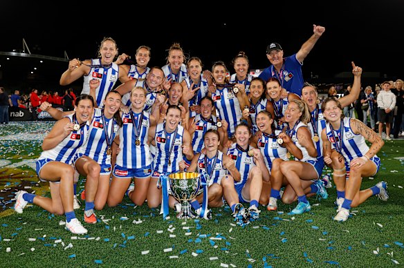 The Kangaroos gather around the 2025 premiership trophy.