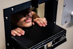 A Silverwater Correctional Centre prisoner peers out of the meal slot in his cell door.