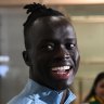 Awer Mabil greeted by fans at Sydney Airport.