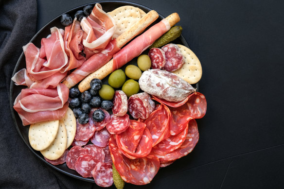 Arrange salumi overlapping in meandering lines on a charcuterie board.