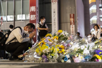 Bir adam, Japonya'nın eski başbakanı Shinzo Abe'nin vurulduğu Yamato-Saidaiji İstasyonu'nun dışındaki bir alanda dua ediyor.