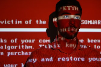 A message from the NotPetya worm projected on a young man; the attack used a variant of the ransomware Petya to destroy computers.