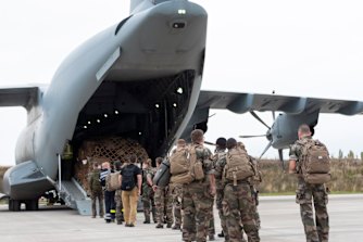 French soldiers prepare to board a military plane to evacuate French citizens on Monday.
