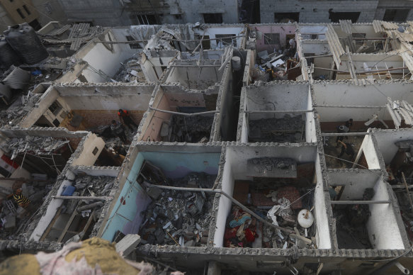 Palestinians look at the destruction after an Israeli strike on residential building in Rafah, Gaza Strip, on Tuesday.