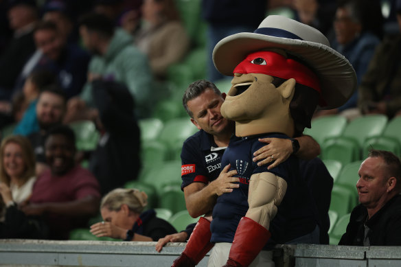 A fan hugs the Melbourne Rebels mascot.