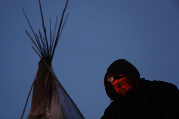 James Logan, a Northern Arapaho Native American from Wyoming, sits by a fire at the Oceti Sakowin camp where people have gathered to protest against the Dakota Access oil pipeline in Cannon Ball, North Dakota, over the past four years.