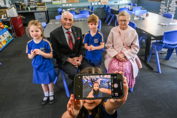 Williamstown Primary School’s oldest surviving students, Barrie Marr, 92, and Mary Booth, 93, get a selfie with three of its youngest students, Grace, Vinny and Sophie.