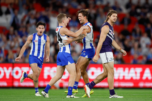 Tom Powell of the Kangaroos (L) celebrates a goal with teammate Jy Simpkin.