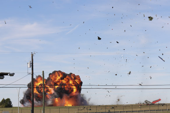 In this photo provided by Nathaniel Ross Photography, a historic military plane crashes after colliding with another plane during an airshow at Dallas Executive Airport in Dallas on Saturday, November 12, 2022. 