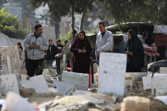 Palestinians visit the graves of people killed in the Israeli bombardment of the Gaza Strip and buried inside the Al Shifa Hospital grounds in Gaza City.