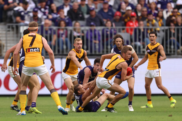 Hawthorn’s Harry Morrison looks to break a tackle from Nat Fyfe.