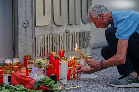 A man lights candles at the entrance of the school after the shooting.