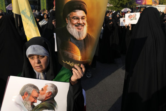 A demonstrator holds posters of slain Hezbollah leader Hassan Nasrallah in an anti-Israeli gathering at Felestin (Palestine) Square in Tehran, Iran, on Tuesday.