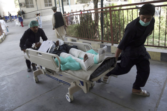 An injured man is carried into a hospital after a car bomb explosion in Kabul.