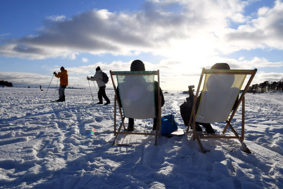 People sit in the sun in Helsinki, Finland, which has yet again been named the happiest country in the world.