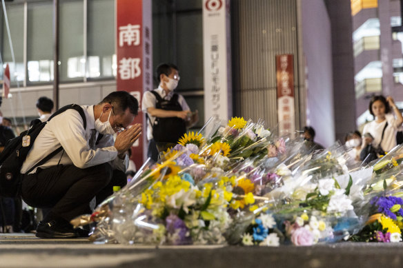 A man prays at a site outside of Yamato-Saidaiji Station where Japan’s former prime minister Shinzo Abe was shot.