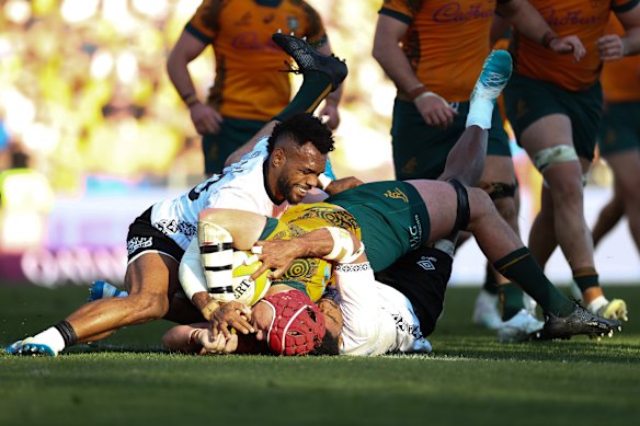 Wallabies captain Harry Wilson squirms over to somehow get the ball down for the winning try.