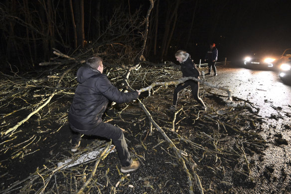 A fallen tree blocking a road is removed, outside Horby in Sweden.