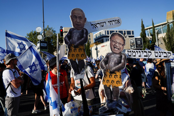 Protesters holding signs featuring Israeli Prime Minister Benjamin Netanyahu and National Security Minister Itamar Ben-Gvir at demonstrations against the judicial overhaul.