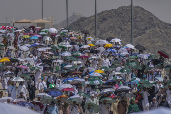 Muslim pilgrims use umbrellas to shield themselves from the sun as they arrive to cast stones at pillars in the symbolic stoning of the devil, the last rite of the annual Hajj.