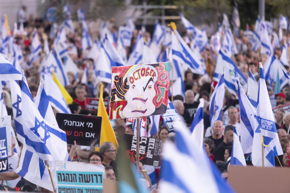 Protesters hold signs during a demonstration against the Israeli Prime Minister Benjamin Netanyahu and his government in late June in Tel Aviv.