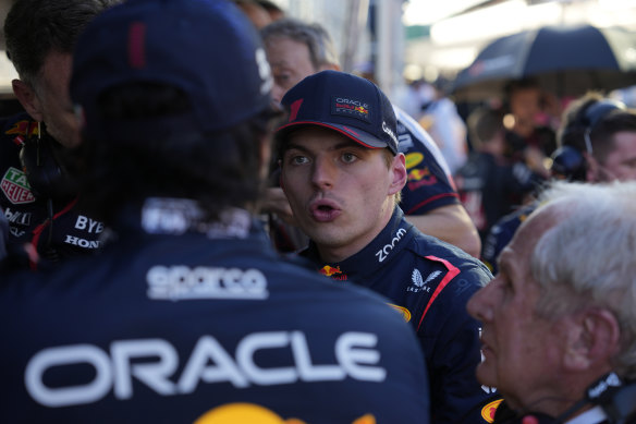 Red Bull driver Max Verstappen talks with his team in pit lane during the third red flag stoppage.