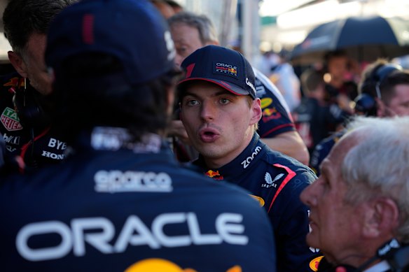 Red Bull driver Max Verstappen talks with his team in pit lane during the third red flag stoppage.