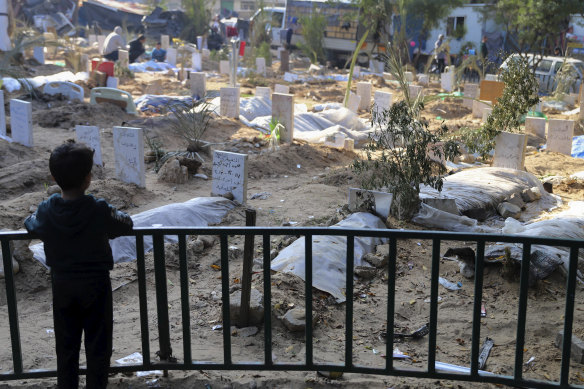 A Palestinian child looks at the graves of people killed in the Israeli bombardment of the Gaza Strip and buried inside the Shifa Hospital grounds in Gaza City in 2023. 