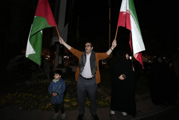 A demonstrator waves Iranian and Palestinian flags during an anti-Israeli gathering at the Felestin (Palestine) Square in Tehran, Iran on Sunday.