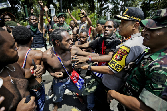 Papuan protesters scuffle with police and soldiers near the presidential palace in Jakarta on August 22, 2019.