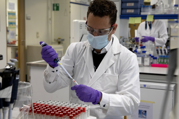 A lab technician fills a test tube during research on COVID-19 at Johnson & Johnson subsidiary Janssen Pharmaceutical in Beerse, Belgium.