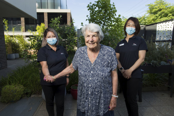 Louise Mathers and Mitsu Kamo lend a hand to Regis Aged Care resident Jean Sarsby.