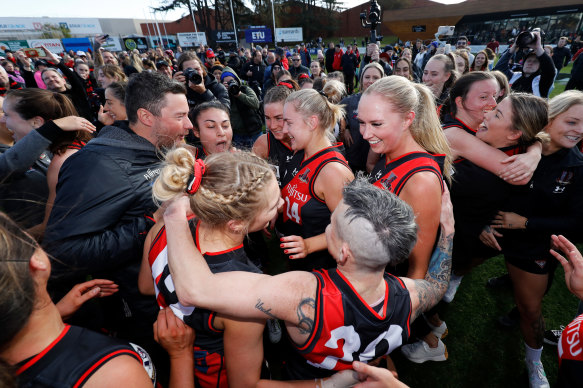 The Bombers embrace after their win.