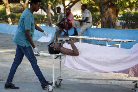 A medical worker pushes the stretcher of a civilian man wounded in an attack on the Afrik hotel in Mogadishu, Somalia, on Sunday.